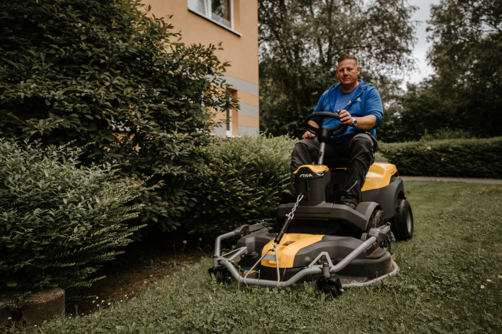 Mitarbeiter bei der Rasenpflege mit einem Aufsitzmäher.